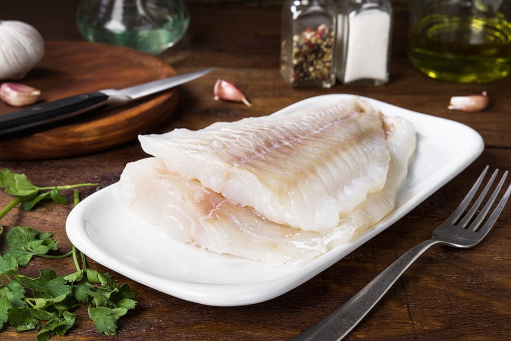 two fillets of fresh cod without cooking in rustic wood