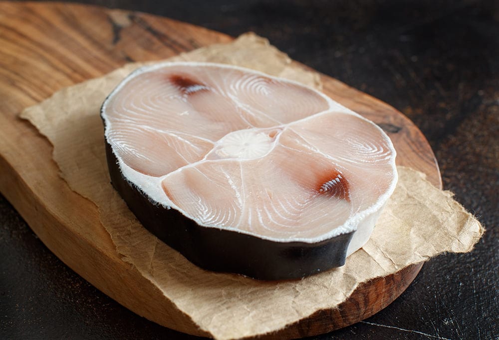 Two shark steak on a dark board