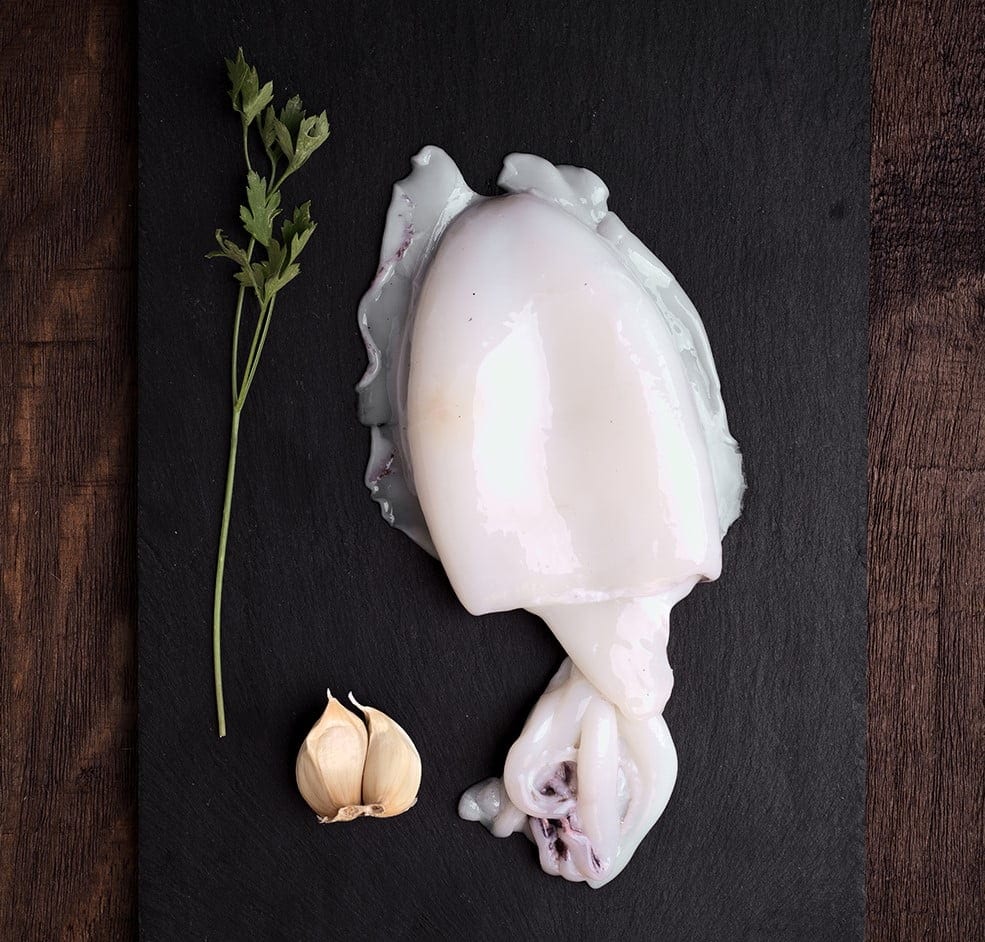 whole raw cuttlefish in dark wood