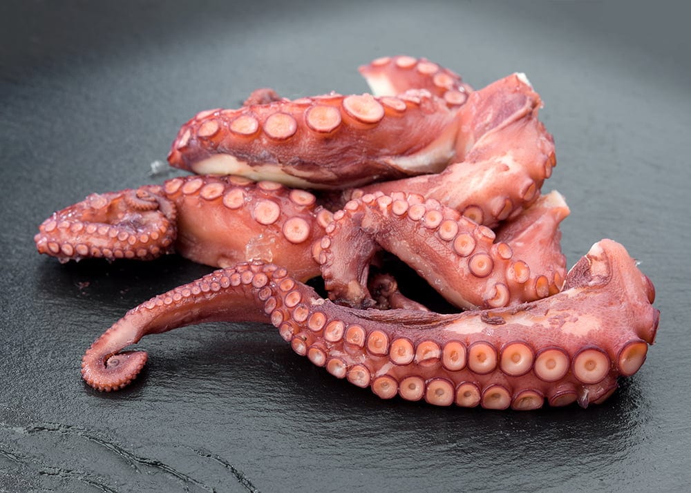 sliced octopus on slate tray